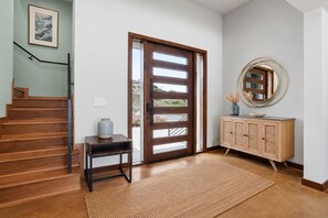A wooden staircase leading to a door with a view of a landscape.
