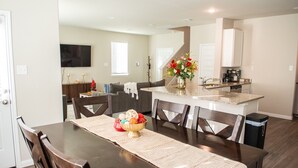 A dining area with a wooden table, chairs, and a decorative centerpiece. - Spacious 4-bedroom house in beautiful Conroe with King Suite (Conroe)