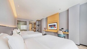 Een moderne hotelkamer met een groot bed, een bureau en een wandgemonteerde televisie.