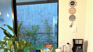 A cozy coffee bar area with a potted plant, a basket of snacks, a coffee maker, and a first aid kit. - Beautiful house in the most exclusive area of ​​San Miguel (San Miguel)
