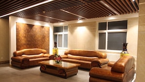 Una sala de estar moderna con sofás de cuero, una mesa de centro de vidrio y jarrones decorativos.