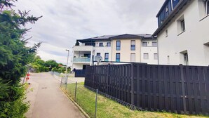 Una calle residencial con casas modernas de dos pisos, aceras y vallas de madera.