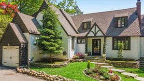 Une maison à deux étages, dotée d’un toit à forte pente, d’un porche à l’avant et d’une pelouse bien entretenue.