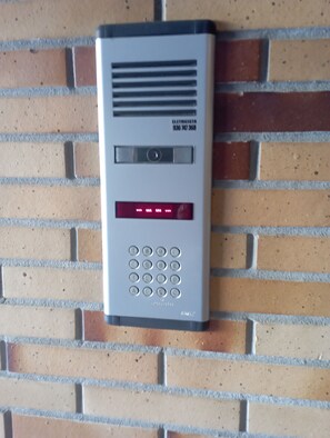 Un sistema de entrada por teclado fijado en una pared de ladrillo.