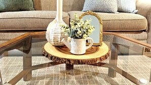 A living room with a glass coffee table, a vase, a teapot, and a framed mirror. - Luxury Winery Country Retreat: Heated Pool, Hot Tub and Games (Niagara-on-the-Lake)