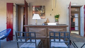 Una habitación con un mostrador de recepción de madera, dos sillas azules, una lámpara, un cartel y una planta.
