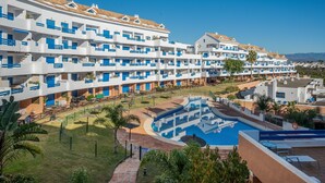 A resort with multiple white buildings, a swimming pool, and a well-maintained lawn. - Apartment 'Kym' with Mountain View, Wi-Fi and Air Conditioning (Duquesa)