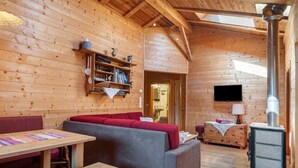 Ein Holzblockhaus-Interieur mit einer Couch, einem Tisch und einem Kamin.