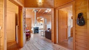 Ein Holzinnenraum mit Kamin, Essbereich und Küche.