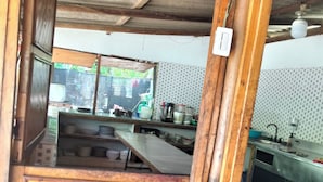 Una cocina rústica con vigas de madera, salpicadero de azulejos y vistas al exterior.