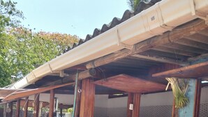 Un edificio con fachada azul, una puerta de madera y un acceso con baldosas.