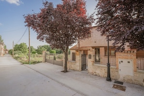 A residential street with a house, a gated entrance, and a clear sky. - Apartment 'Velasco I' with Private Terrace, Wi-Fi and Air Conditioning (Cabañas de Polendos)