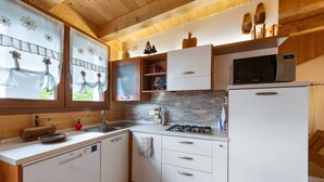 Una cocina con armarios de madera, lavavajillas, microondas y estufa.