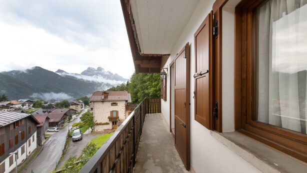 A balcony with a view of a mountain and a village.