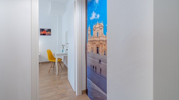 Ein Zimmer mit Essbereich, einem Gemälde eines Gebäudes und Holzboden.