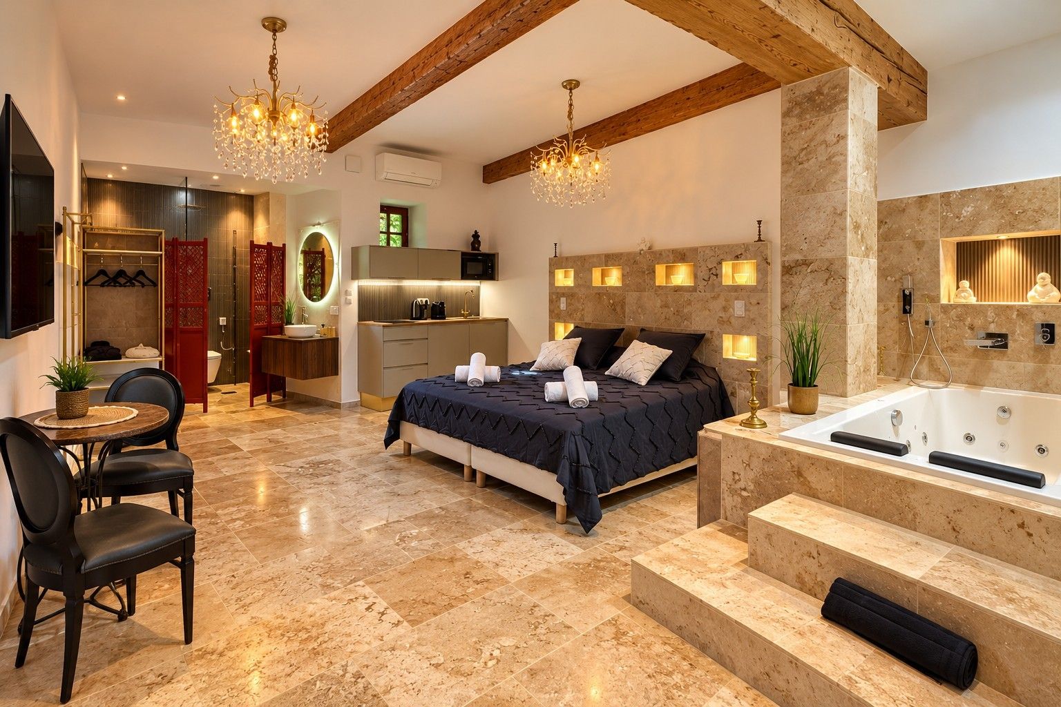 Een moderne slaapkamer met een groot bed, een aparte badkamer met badkuip, en een eethoek met een tafel en stoelen.