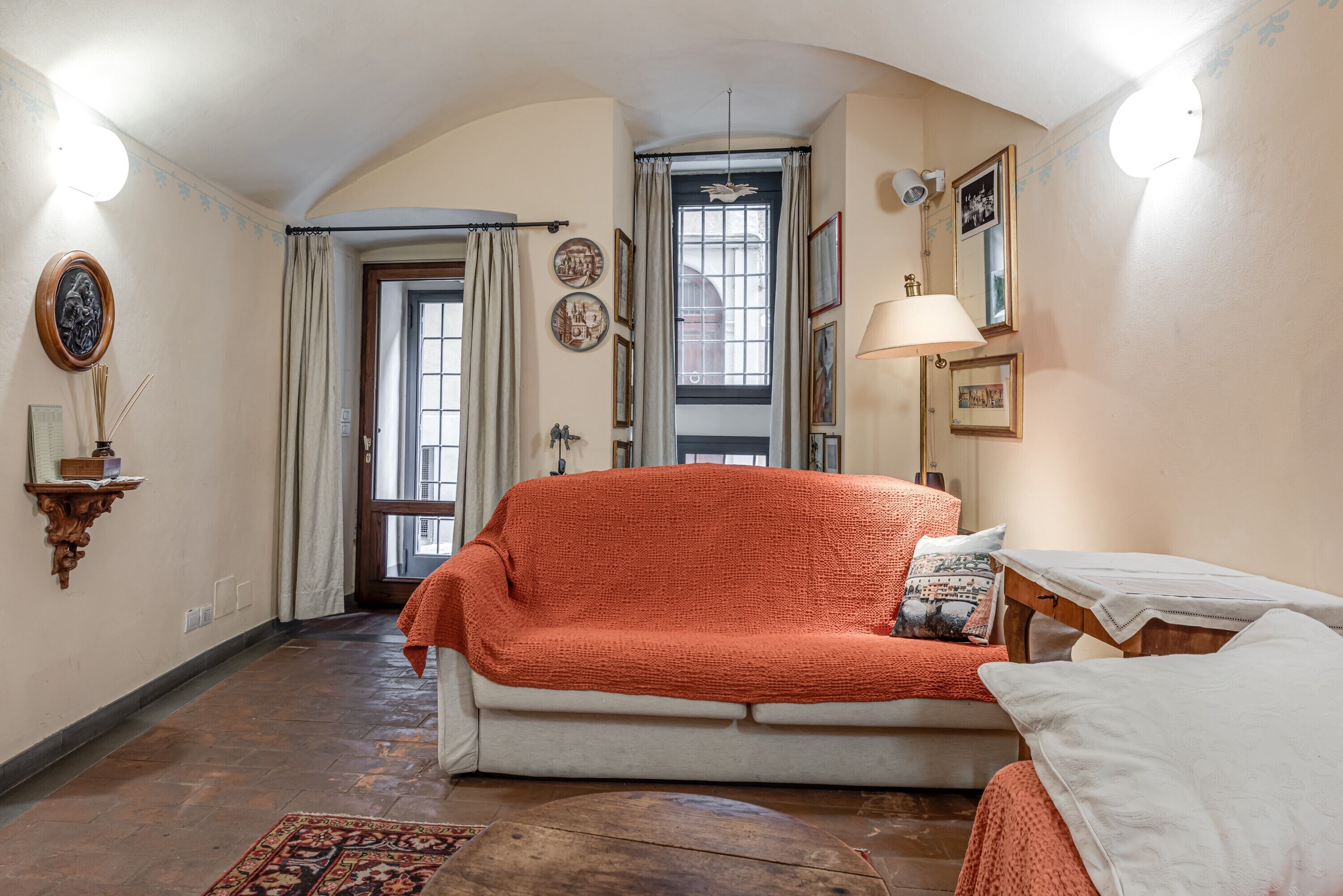 A cozy living room with a sofa, a table, and a lamp.