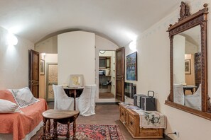 Una camera accogliente con un letto, un tavolo, una sedia, un armadio e uno specchio grande.