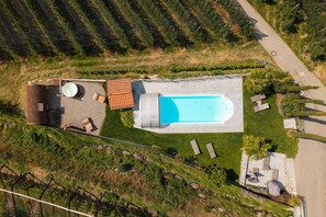Vue aérienne d’une propriété dotée d’une piscine, d’un espace salon extérieur et d’un patio.