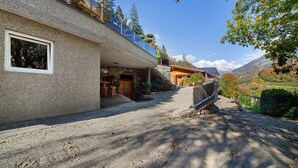A building with a stone facade, a window, and a paved driveway leading to a wooden door. - Chalet Palme: Mediterranean Garden & Terrace, Pool & Hot Tub for All Guests (Rifiano)