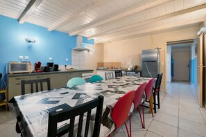 A kitchen with a dining table, chairs, and a microwave.