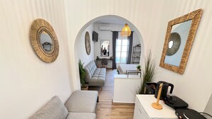 Een modern interieur met een bank, een kitchenette en een eettafel.
