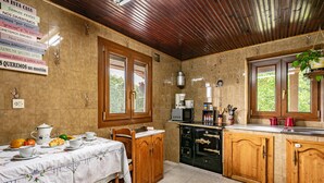 A kitchen with wooden cabinets, a dining table with a white tablecloth, and a coffee machine.