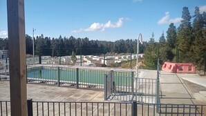 Zona de piscina con vistas a una ladera boscosa.