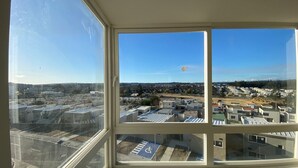 Vista desde una ventana en un rascacielos, con vista a una zona residencial con varios edificios y un cielo despejado.