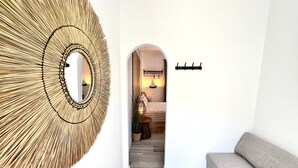A hallway with a large circular wall decoration, a sofa, and a bed with a headboard.