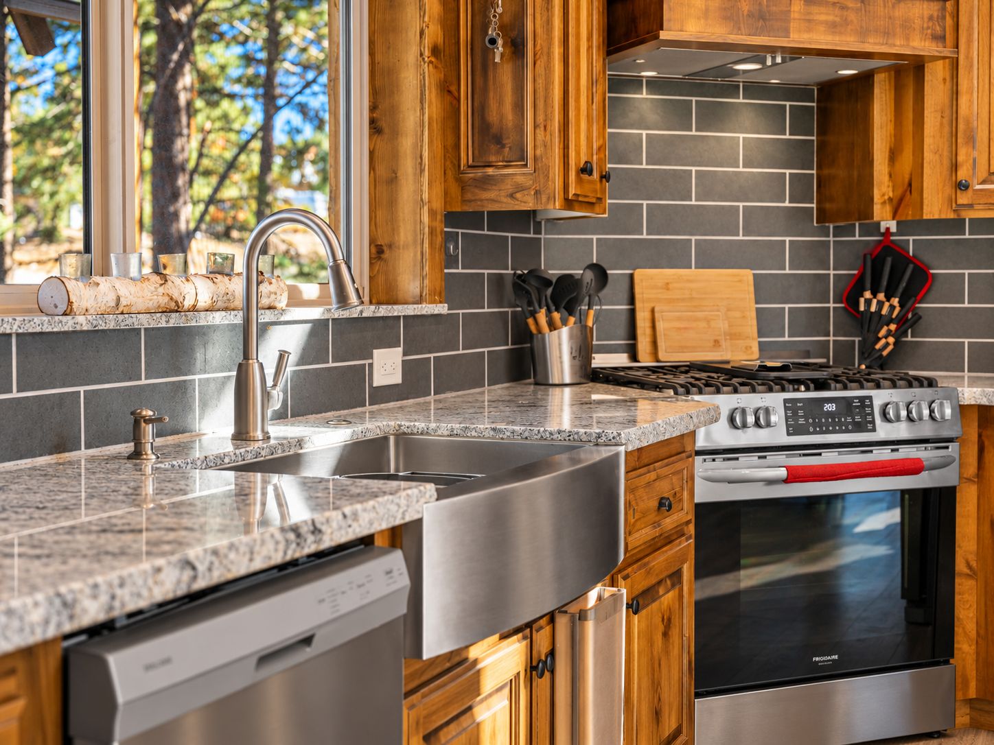 Una cocina con encimeras de granito, electrodomésticos de acero inoxidable y armarios de madera.