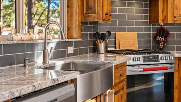 Una cocina con encimeras de granito, electrodomésticos de acero inoxidable y armarios de madera.