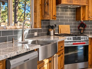 A kitchen with granite countertops, stainless steel appliances, and wooden cabinets. - Shem Shack (Big Bear City)