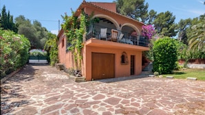 A house with a stone-paved entrance, a wooden door, and a balcony with chairs. - Los Caños, Mediterranean Villa, bbq, pool, 5min-beach (Jávea)