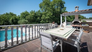 A deck with a pool, outdoor seating, and a barbecue area. - Holiday Home 'Maison Zoé' with Private Pool, Private Terrace and Wi-Fi (Saint-Laurent-de-Neste)