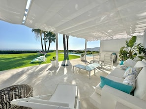 A covered outdoor seating area with a pool, chairs, and a view of the ocean. - Villa 'Amarna' with Sea View, Wi-Fi and Air Conditioning (La Herradura)