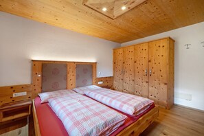 A bedroom with a wooden bed, a wardrobe, and a desk.