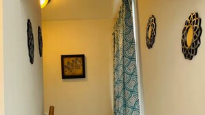 A staircase with a wooden handrail, carpeted steps, a decorative column, and a framed welcome sign.