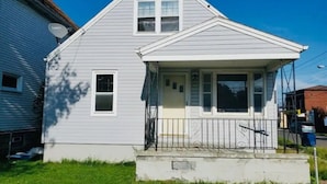 A two-story house with a front porch and a small balcony.