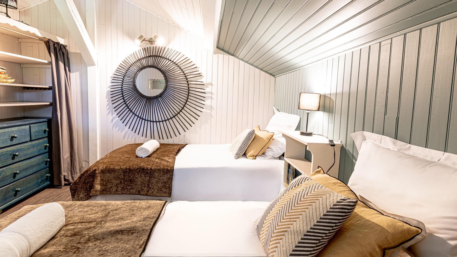 Una habitación de hotel con dos camas, un aparador, un espejo y una lámpara.
