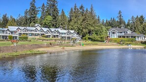 A lakeside hotel with multiple buildings, a dock, and a well-maintained lawn. - Good Life (lower Suite) @ Shawnigan Beach Resort. (Shawnigan Lake)