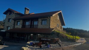 A stone building with a balcony, a dock, and a sign reading 'QUINTES PLAYA'. - Villa 'Quintes' with Sea View, Private Terrace and Wi-Fi (Villaviciosa)