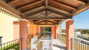 A covered outdoor patio with a table and benches, stone pillars, and a view of the surrounding area. - Villa 'Pretziosa' with Private Pool, Wi-Fi and Air Conditioning (Castiadas)