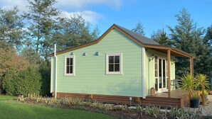 A single-story house with a gabled roof, a front porch, and a small deck.