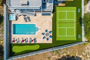 An aerial view of a property with a swimming pool, tennis court, and outdoor seating area. - A Shore Thing: Private Pool, Hot Tub, Elevator, Currituck Club Amenities (Corolla)