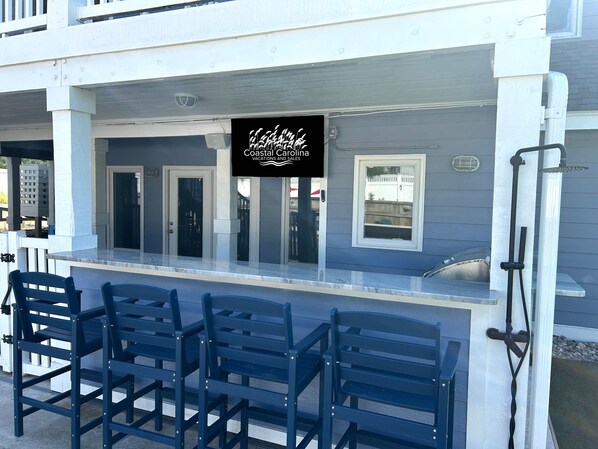 A coastal property with a bar area featuring a sign for Coastal Carolina Vacations and Sales.
