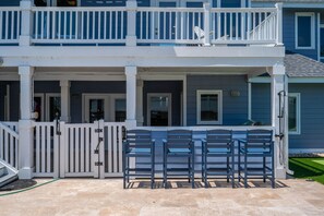 Un bâtiment à deux étages doté d’un balcon, d’une entrée sécurisée et d’un espace extérieur aménagé pour s’asseoir.