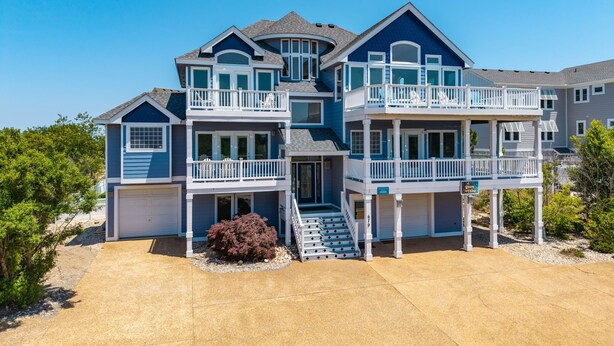 Een meerlaags huis met een garage, een balkon en een trap die naar de bovenverdiepingen leidt.