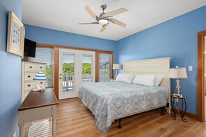 A bedroom with a bed, a ceiling fan, a dresser, a TV, and a balcony door. - A Shore Thing: Private Pool, Hot Tub, Elevator, Currituck Club Amenities (Corolla)