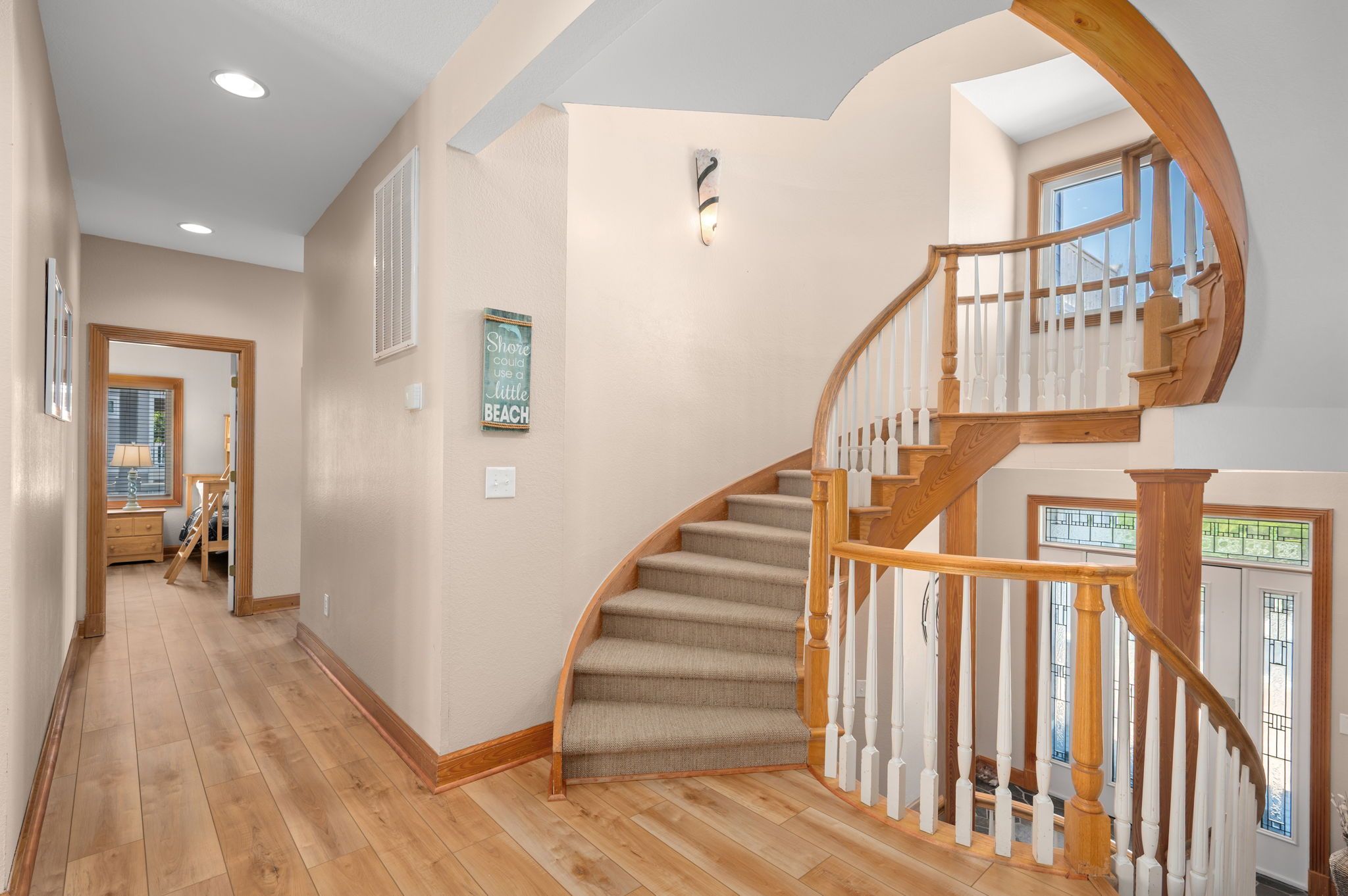 A staircase with wooden balusters and beige carpet, leading to a second floor.
